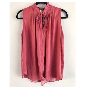 Pink flowy sleeveless blouse.